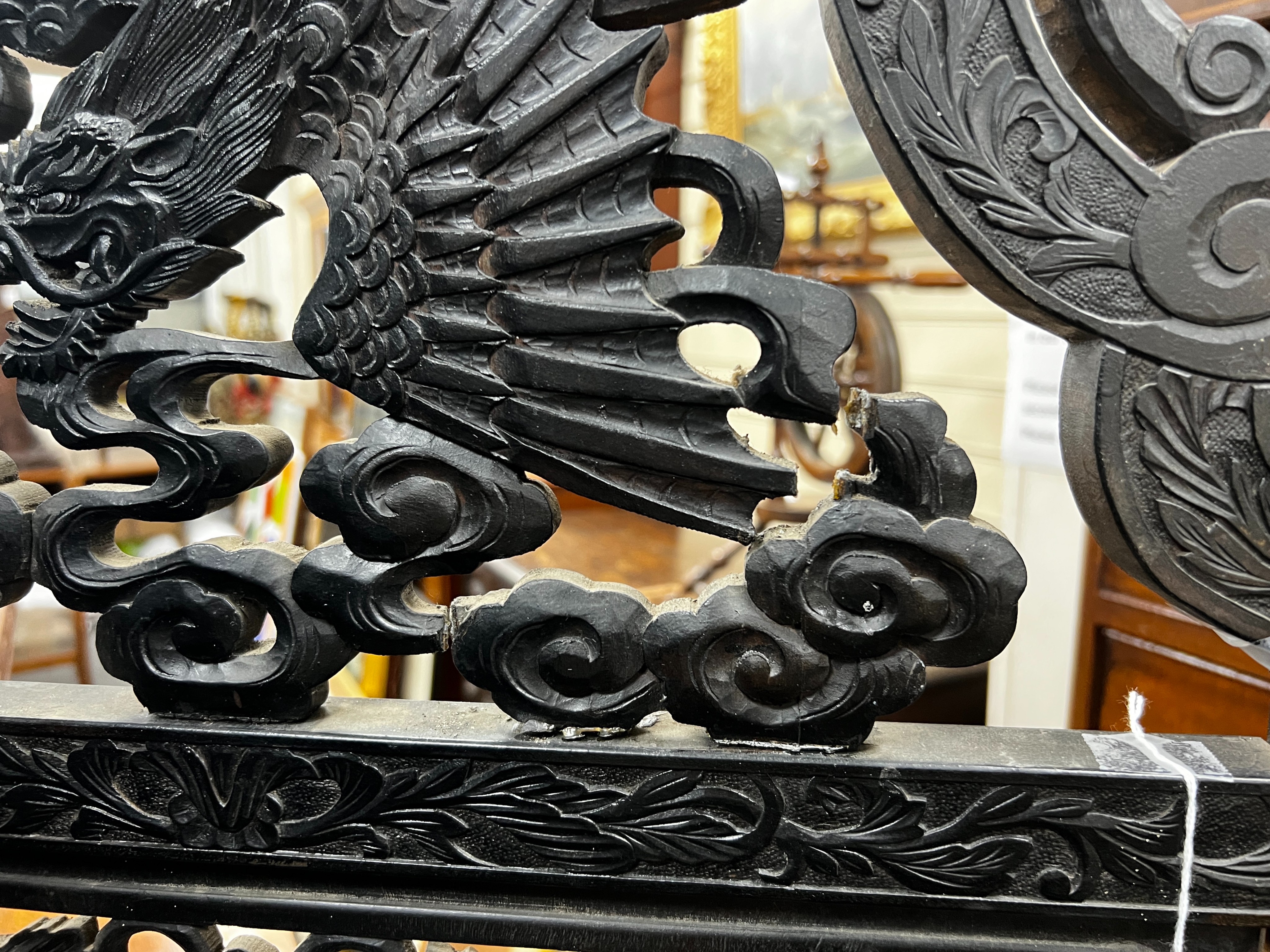 An early 20th century Japanese carved ebonised wood four fold dressing screen, width 56cm, height 173cm